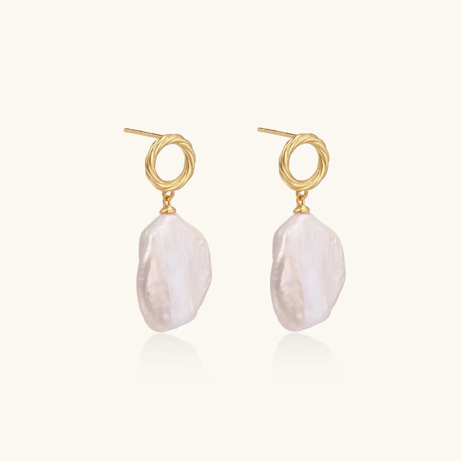 18K gold vermeil twisted circle studs with organic white baroque pearl drops on cream background
