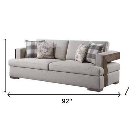92" Beige Fabric Sofa And Toss Pillows With Brown Legs