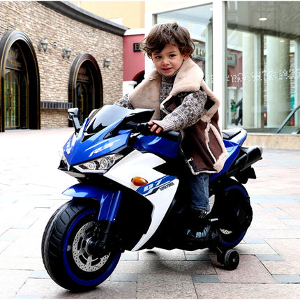 Child sitting on a toy motorcycle in an urban setting