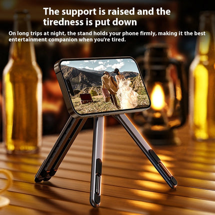Phone stand on a wooden table with a scenic phone screen, surrounded by bottles and a lantern.