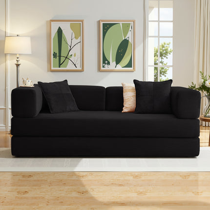 Black sofa in a living room with decorative pillows and framed artwork on the wall.